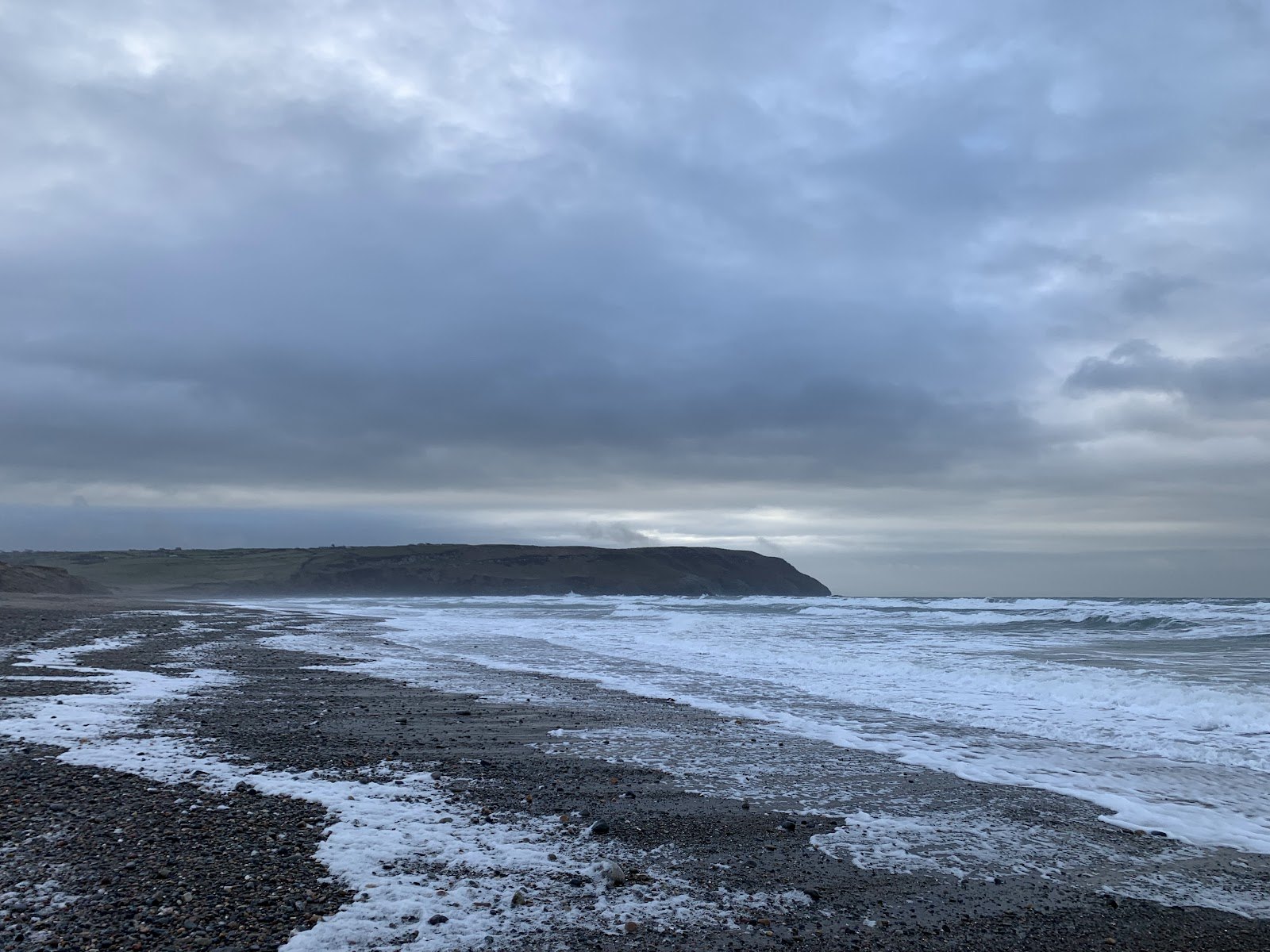 Porth Neigwl bay under a heavy sky, with swell running towards the shore
